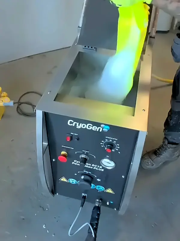 Dry ice pellets pouring from a bag into the hopper of a dry ice blaster, with cold fog rolling off them.